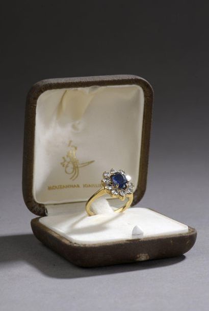  18k yellow gold surround ring 750‰, set with an oval shaped sapphire surrounded...