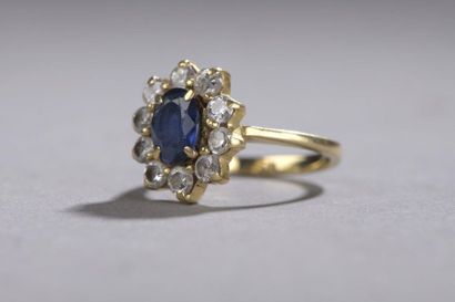 null Bague entourage en or jaune, 18k 750‰, ornée d’un saphir de forme ovale entouré...