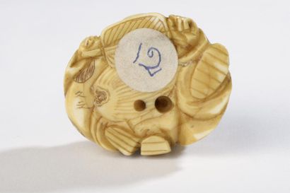 null Netsuke en ivoire de morse, Daikoku accroupi, un éventail dans la main gauche,...