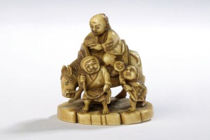 null Petit okimono en ivoire dans le style des netsuke, trois hommes et un cheval.
Signé...