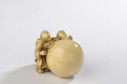 null Netsuke en ivoire, trois enfants astiquant une énorme sphère.
Signé Tomomasa.
Japon,...