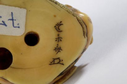 null Netsuke en ivoire à patine jaune, samouraï accroupi, l'air farouche, les yeux...