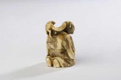 null Netsuke en ivoire, attrapeur de rats agenouillé avec sa boîte au sol alors qu'un...