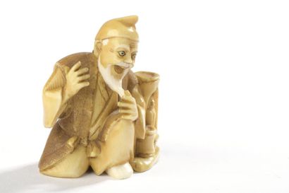 null Netsuke en ivoire, personnage agenouillé se tenant la barbe, une petite figure...