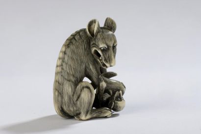 null Netsuke en ivoire d’hippopotame ou de phacochère, rehaussé à l’encre, loup maîtrisant...