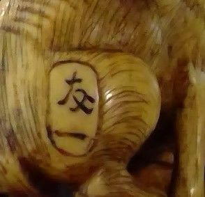 null Netsuke en ivoire, chienne assise, son petit entre ses pattes, les yeux incrustés.
Signé...