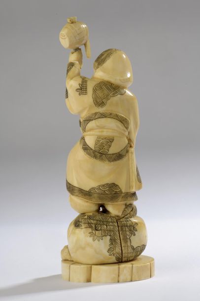  Statuette en ivoire de morse, Daikoku debout sur son sac des richesses, son maillet...
