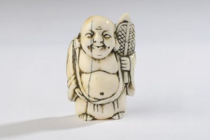 null Netsuke en corne de cerf, Hotei debout, son éventail à la main.
Non signé.
Japon,...