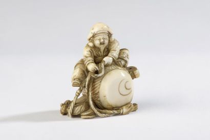 null Netsuke en ivoire de morse, Daikoku assis sur un énorme maillet, une corde dans...