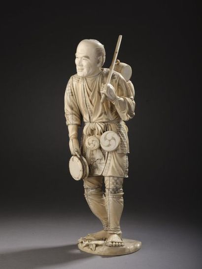 null OKIMONO in ivory carved and enhanced with ink, peddler carrying barrels. Cracks,...