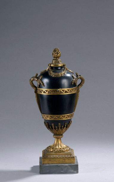 null PENDULE en bronze laqué noir et bronze doré en forme de vase ovoïde, couvert,...