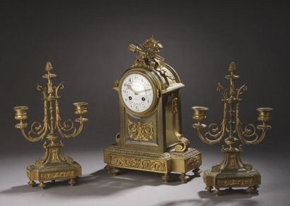 null CHIMNEY GARNITURE in gilt bronze. It includes a bronze boundary clock with a...