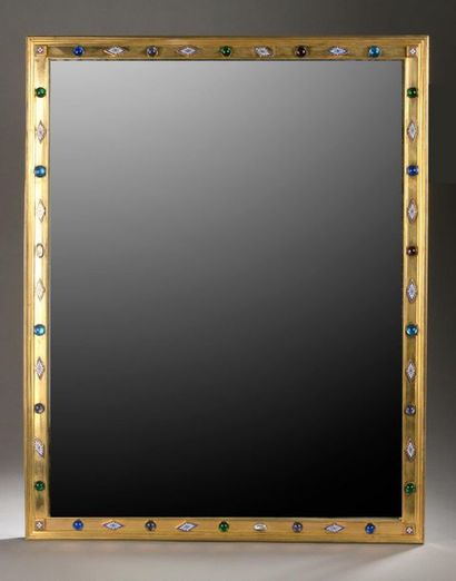 null MIRROR in a gilded metal frame set with cabochons and enamelled lozenges.

Late...