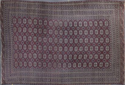 null BOUKHARA CARPET decorated with gulhs on a wine lees background. Border of eighteen...