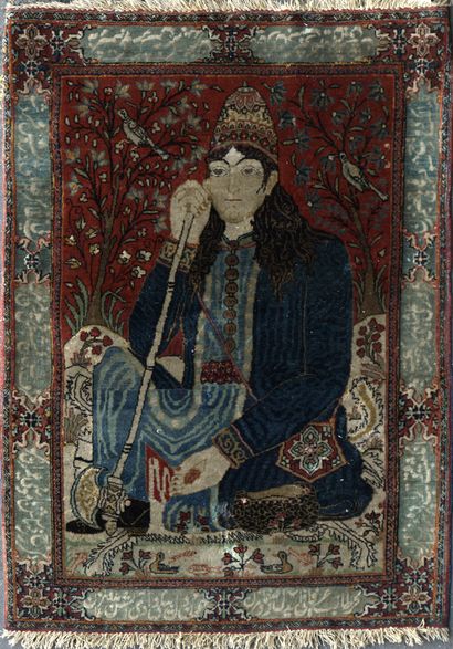 null SMALL KECHAN CARPET decorated with a sitting dervish holding his axe. Border...