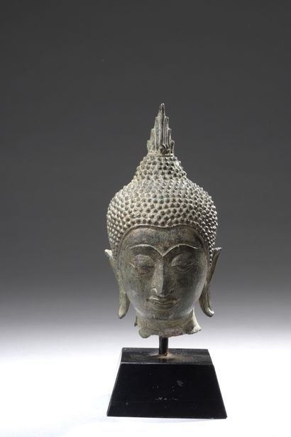 null BUDDHA HEAD in bronze with green patina, the ushnisha flamed, the face sketching...