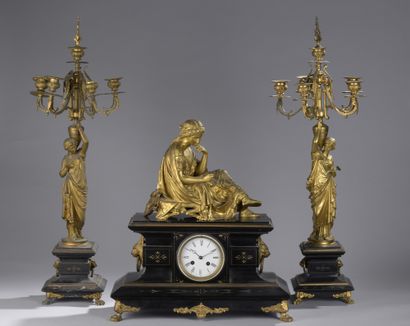 null CHIMNEY GARNITURE in black marble and gilt bronze. Clock decorated with a figure...