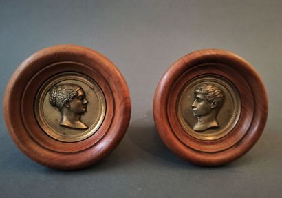 null Two bronze medallions representing a man and a woman profile. 

Wooden frame

Dim....