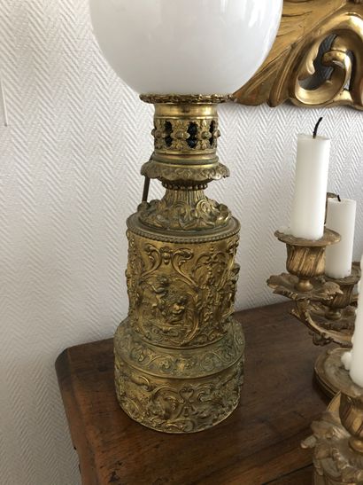 null A pair of gilt metal oil lamps decorated with putti. 

19th century

Total height...