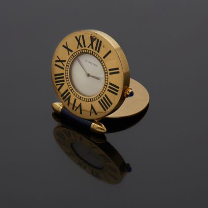 null CARTIER - Gilt metal travel clock, Must model. Signed round dial, cream background,...