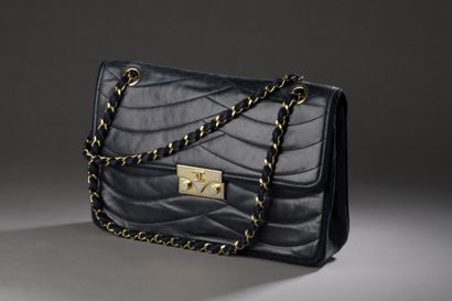 null CHANEL, circa 1980

Navy lambskin leather bag with wavy stitching, trimmed with...