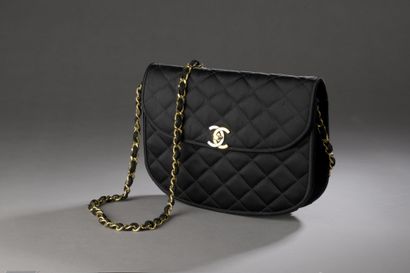 null CHANEL, circa 1980

Half-moon bag in black quilted satin, CC clasp in gold and...