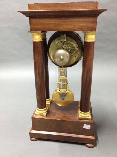 null A mahogany and mahogany veneer portico clock with a guilloche brass frame.


19th...
