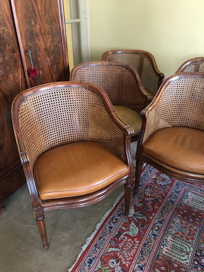 null Suite de cinq fauteuils cannés en bois naturel et galettes de cuir. 


Style...