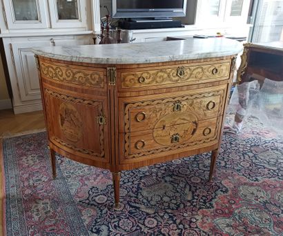 null A rosewood veneered half-moon chest of drawers decorated with friezes of leafy...