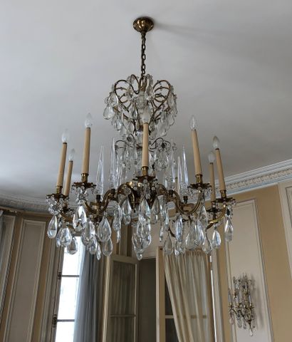 null A ten lights chandelier in bronze and gilt brass, water drops, glass and crystal...