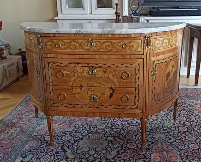null A rosewood veneered half-moon chest of drawers decorated with friezes of leafy...