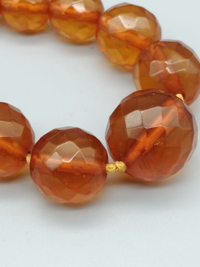  Collier d’ambre (traité), composé de boules facettées en chute, enfilées sur fil...