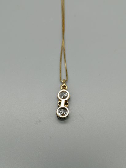 null An 18K 750‰ two-tone gold pendant, adorned with two old-cut diamonds interspersed...