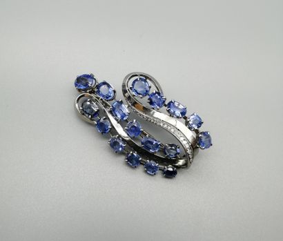 null An 18K white gold 750‰ scroll-shaped brooch set with 17 oval and brilliant sapphires...