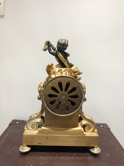 null DELARUE clock in Paris in gilt bronze surmounted by a cherub holding a garland...