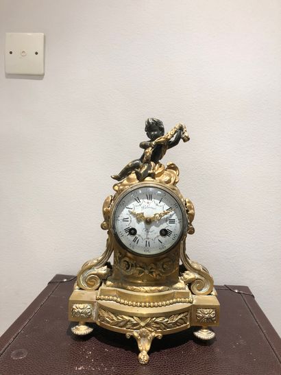 null DELARUE clock in Paris in gilt bronze surmounted by a cherub holding a garland...