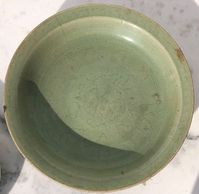 null A celadon glazed stoneware circular dish with incised floral decoration under...