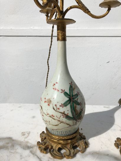 null Paire de vases en porcelaine à décor feuillagé, montés en lampe à quatre bras...
