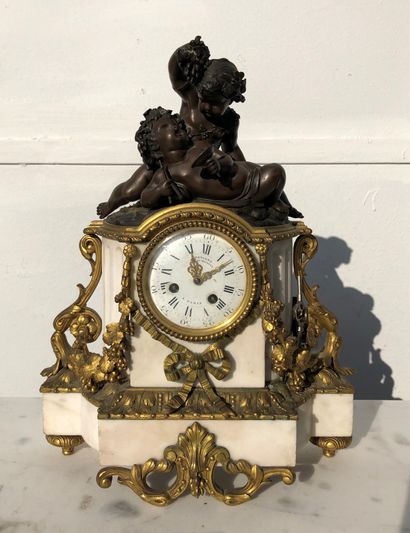  A patinated and gilt bronze and white marble clock decorated with two Bacchus children,...