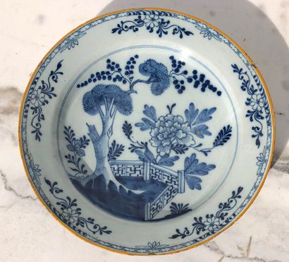 null Round earthenware dish decorated in blue monochrome underglaze of flowery hedge....