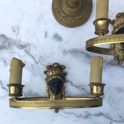 null A pair of ormolu and black painted sconces with masks (23 x 12 cm) and an ormolu...