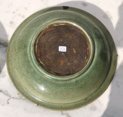 null A celadon glazed stoneware circular dish with incised floral decoration under...