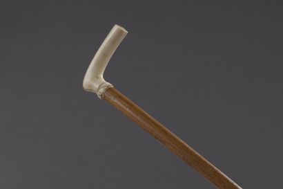 null Wooden cane, the pommel in ivory** with decoration in light relief of a motif...