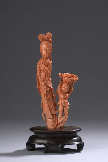 null Statuette in orange-red coral* representing a young woman standing, a child...