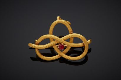null An 18K yellow gold 750‰ brooch, forming a knotted loop set with a red stone.

Province...
