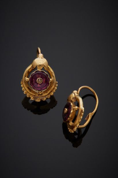 null A pair of 18K yellow gold 750‰ sleepers, beaded and adorned with a garnet studded...