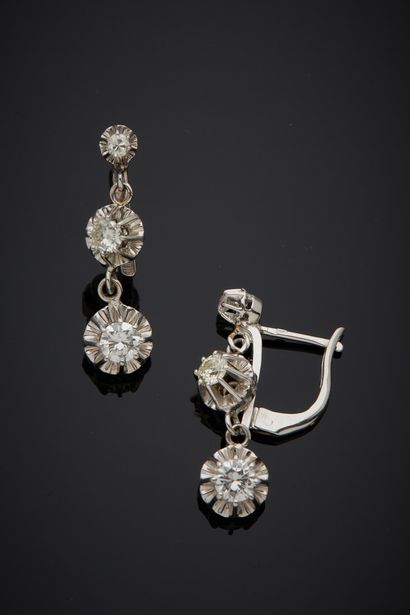 null A pair of 18K white gold 750‰ sleeper earrings, adorned with an articulated...