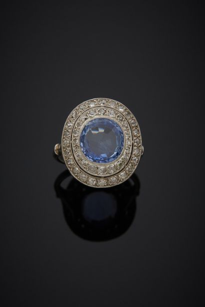 null Platinum 850‰ double-encircled ring, set with an oval-shaped sapphire, surrounded...