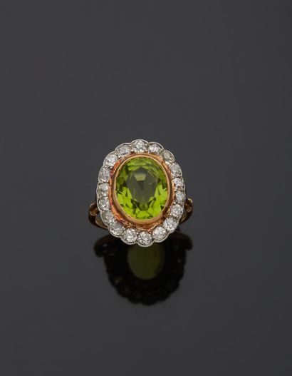 null An 18K yellow gold 750‰ and platinum 850‰ ring, set with an oval-shaped peridot...