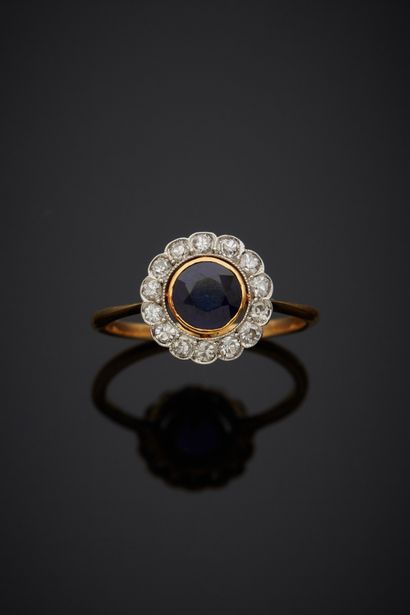 null A round 18K yellow gold 750‰ and platinum 850‰ band ring, adorned with a sapphire...